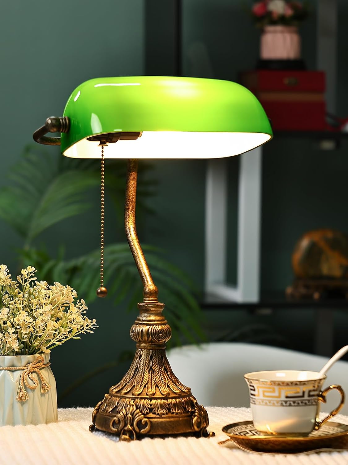 green glass bankers lamp shade replacement on an ornate brass lamp with coffee cup and flowers