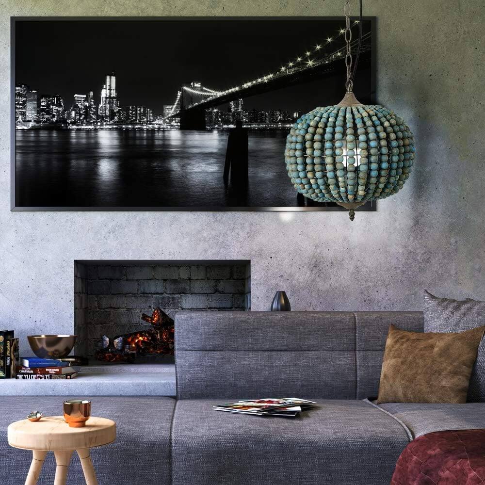 Blue Wood Bead Globe Pendant Light hanging in a modern living room with a black and white cityscape.
