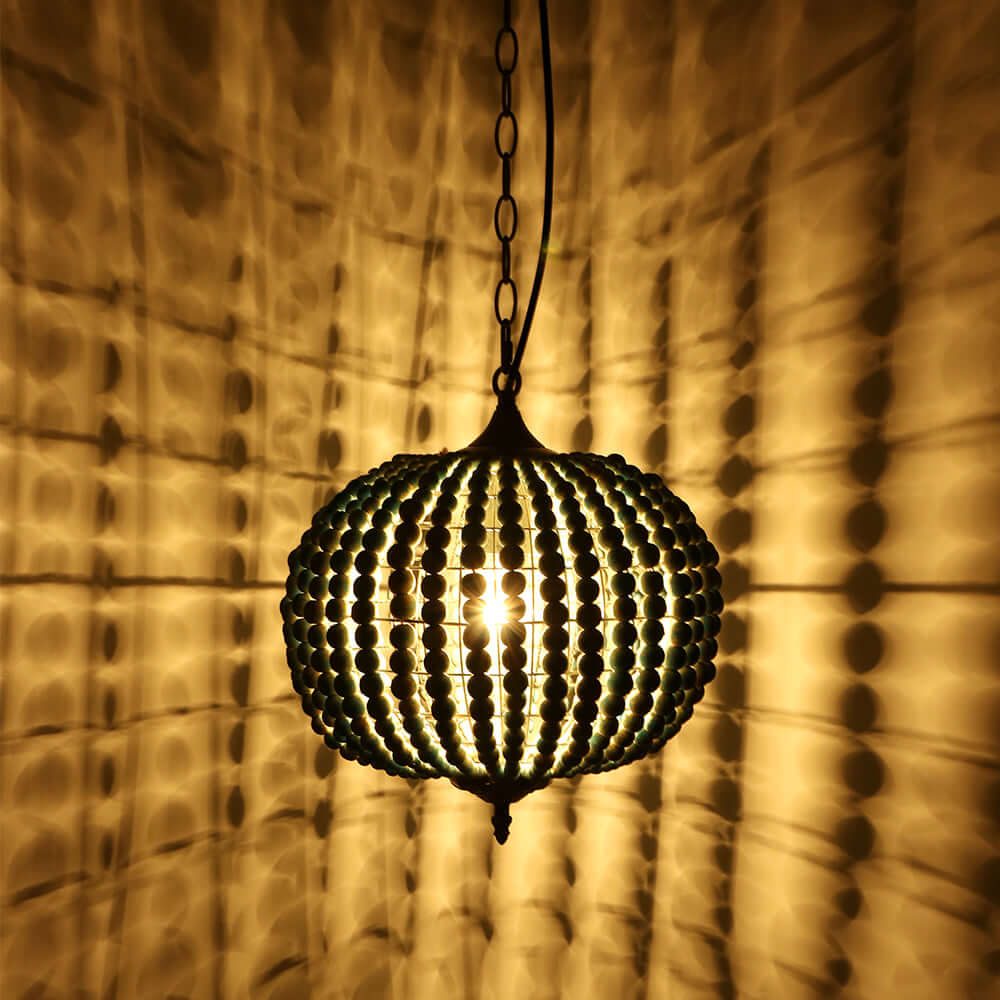 Blue Wood Bead Globe Pendant Light illuminating a warm space with artistic shadows on the walls.