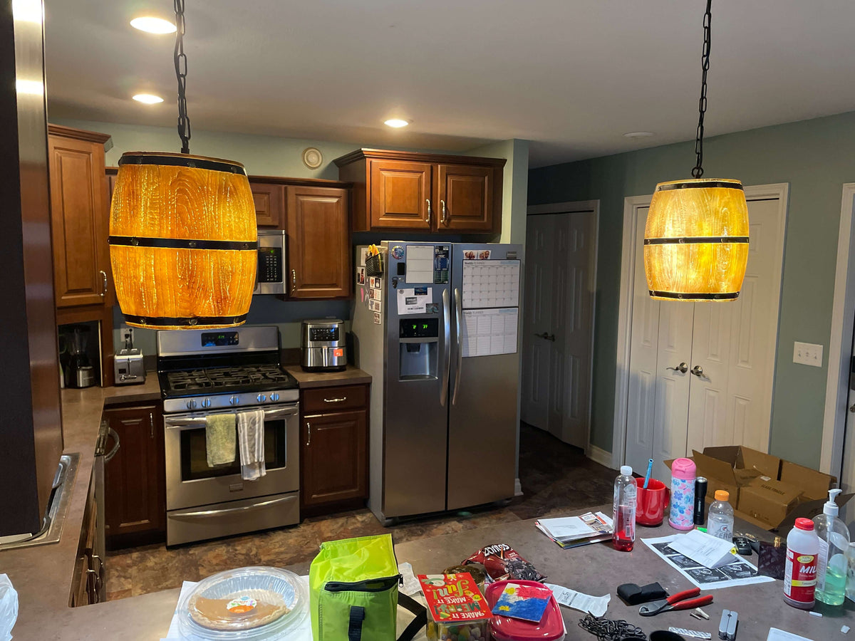 Newrays Antique Artificial Resin Wine Barrel Pendant Lamp hanging in a kitchen, showcasing its warm lighting and design.