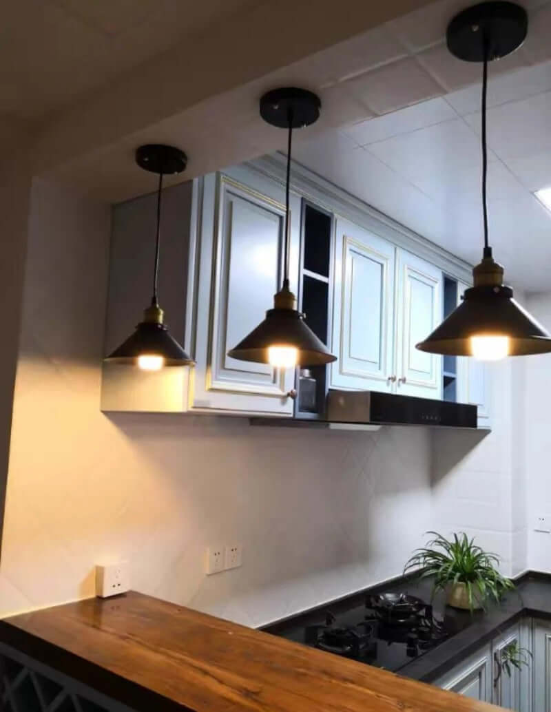 Industrial Retro Black Iron Pendant Light,2 Pack hanging in a modern kitchen with wooden bar and stylish cabinets.