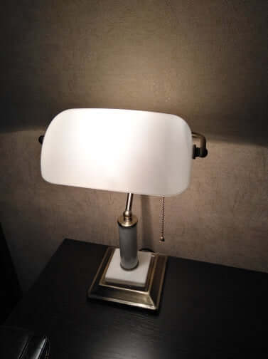 milk white glass bankers lamp shade replacement on a stylish desk lamp with elegant base and pull chain.