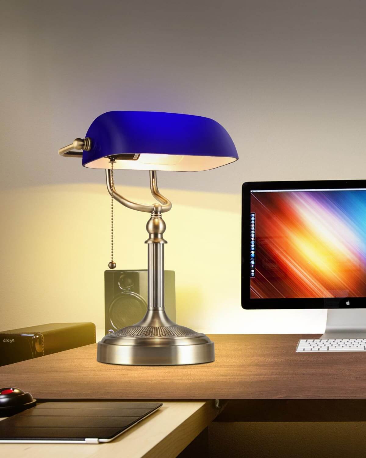 Newrays Blue Glass Bankers Desk Lamp on an elegant desk with a computer and accessories.