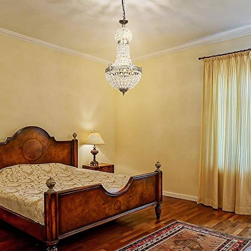 Vintage Royal Empire Crystal Chandelier illuminating a beautifully styled bedroom with wooden furnishings.