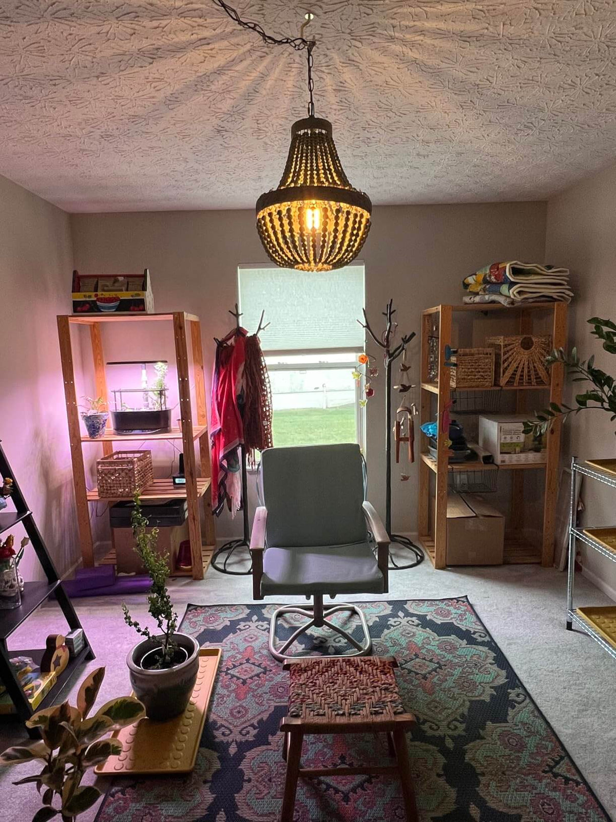 Wood Bead Chandelier Pendant Lights Gray Blue hanging in a cozy room with plants and furniture.