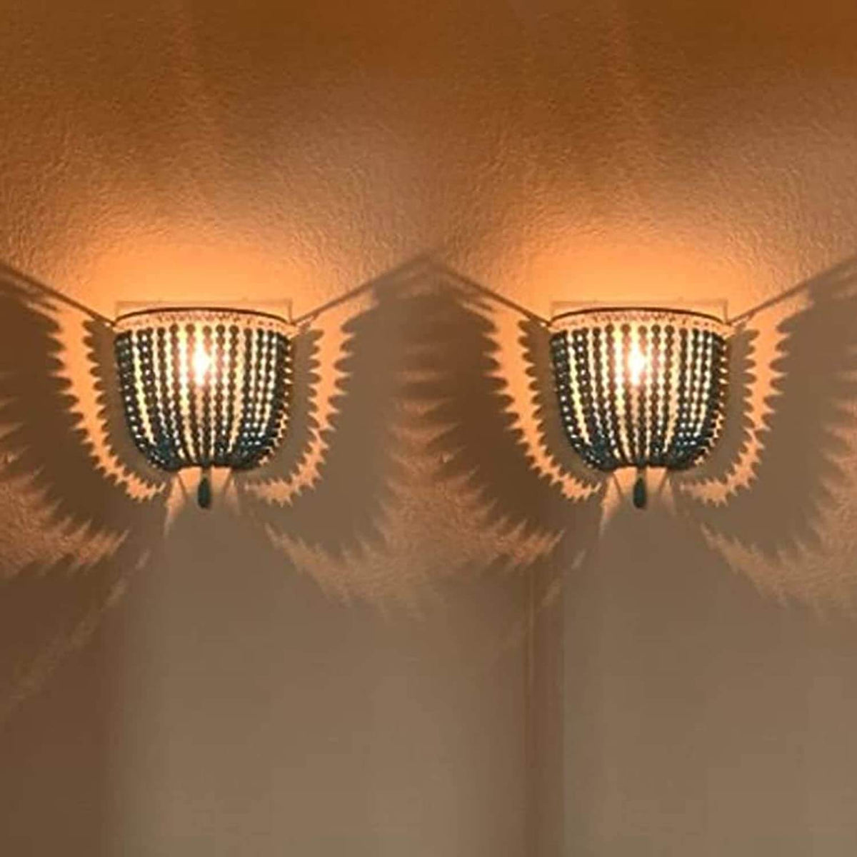 2 Pack Wood Bead Wall Lamp,Hard Wired,E12/E14 Socke illuminating a wall, casting unique shadows.