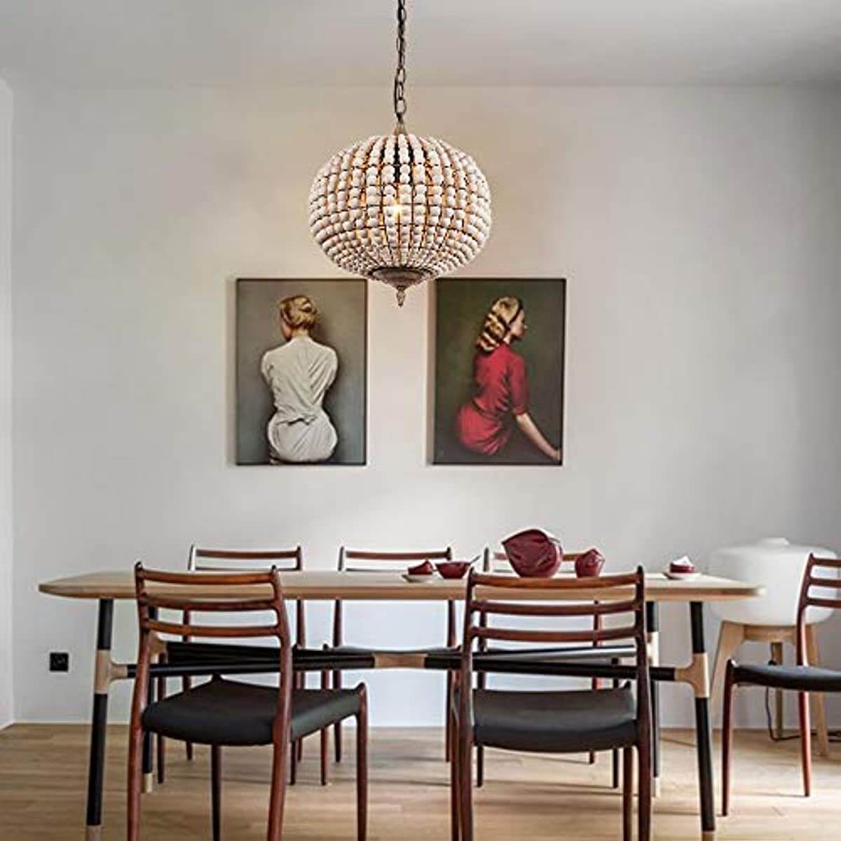 Globe Wood Bead Chandelier Pendant Gray White Finishing hanging above a stylish dining table with artwork on the walls.