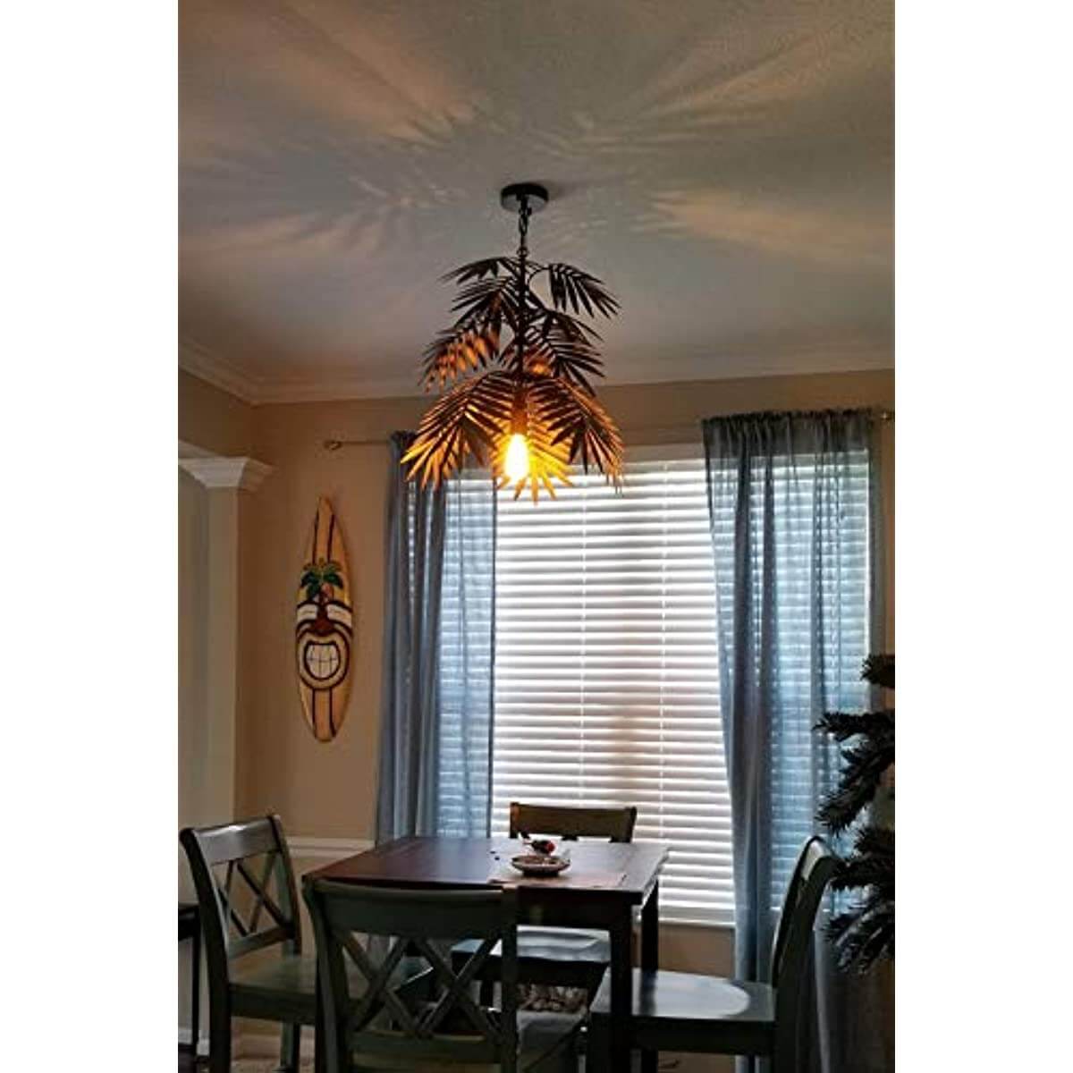 Adjustable Tropical Coconut Leaves Chandelier Unique Rustic Tree Lamps illuminating a dining area with wooden table and chairs.
