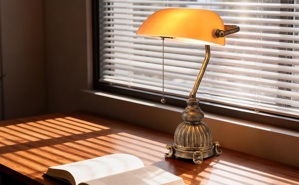 Newrays retro amber glass desk lamp illuminating a wooden desk with a book and natural light from a window.