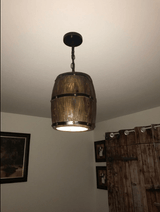 Wood Wine Barrel Pendant Lamp Unique Kitchen Bar Light H30 hanging from the ceiling, illuminating a rustic interior.